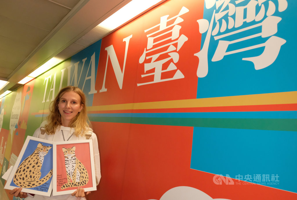 免費為台灣集集彩繪列車畫石虎的俄羅斯插畫家莫洛措娃(Katya Molodtsova)17日清晨搭機抵台,大方拿出畫作並開心揮手。中央社記者邱俊欽桃園機場攝 108年9月17日