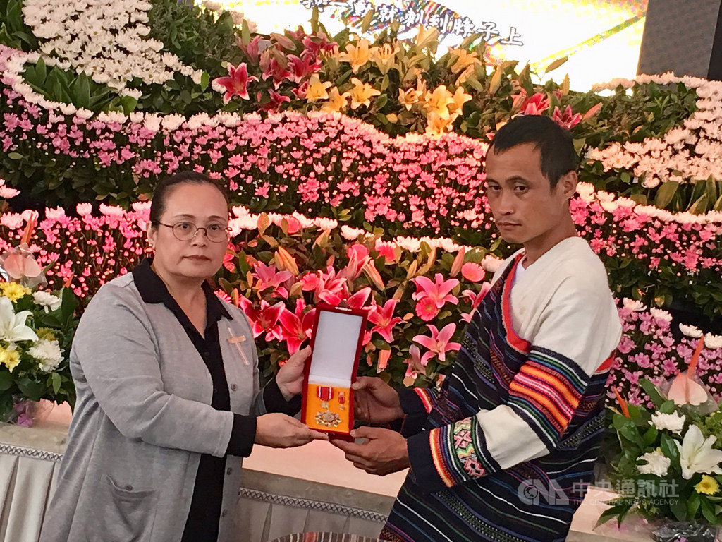 苗栗縣泰雅族文面國寶柯菊蘭日前病逝,原住民族委員會副主委伊萬.納威(Iwan Nawi)(左)21日親自前往柯菊蘭故居追頒一等原住民族專業獎章,由柯菊蘭的孫子王伯元(右)代為接受。(原民會提供)中央社記者吳欣紜傳真 108年9月21日