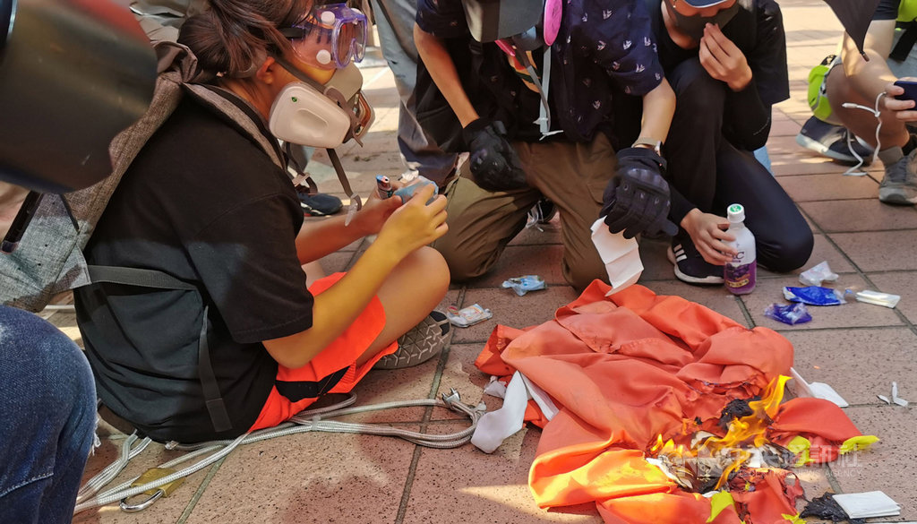 香港反送中人士21日下午舉行遊行,其中有人在屯門大會堂旁拉下中國國旗並燒燬。中央社記者張謙香港攝 108年9月21日