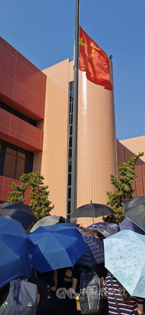 香港反送中人士21日下午舉行遊行。圖為部分人士在屯門大會堂旁拉下中國國旗,隨後燒燬旗幟。中央社記者張謙香港攝 108年9月21日