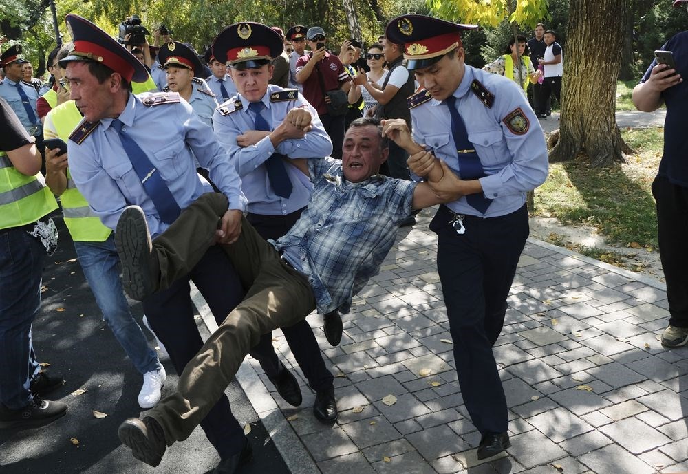 中國西北方的鄰國哈薩克最大城阿拉木圖21日爆發街頭示威,反對中國對哈薩克影響力日增是訴求之一,有示威者被警方強行拖上警車。(美聯社)