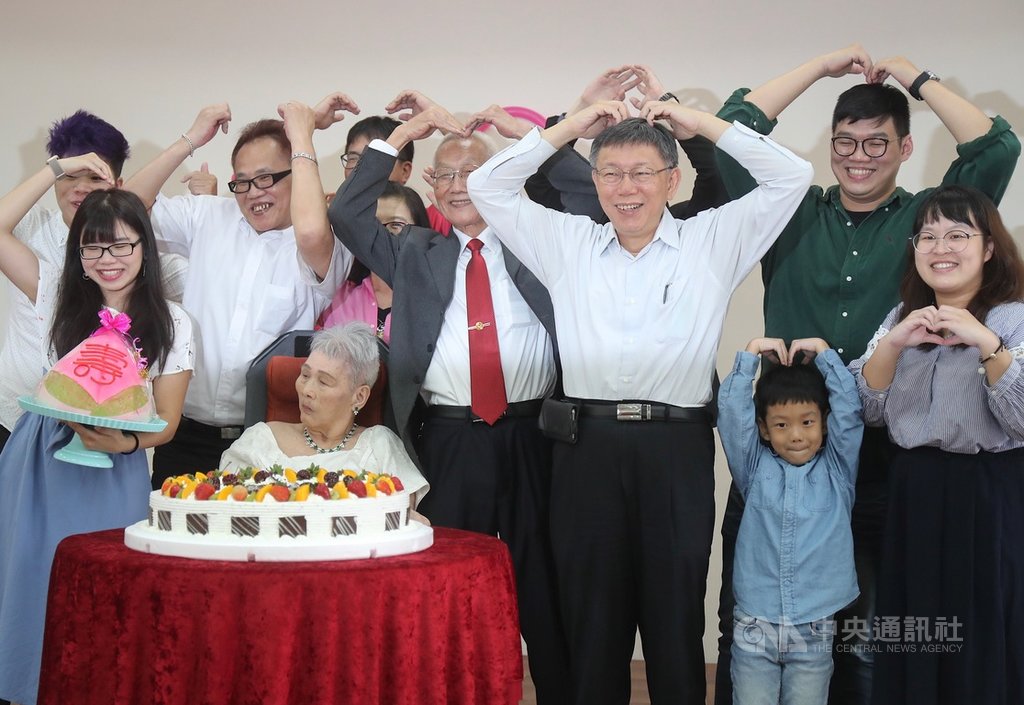 弘道老人福利基金會為83歲的阿公詹瑞東(前左3)與太太韓水金(前左2)圓夢,22日在內湖五分區民活動中心舉辦婚禮,台北市長柯文哲(前右3)出席與會,與家屬一同手比愛心祝福。中央社記者裴禛攝 108年9月22日