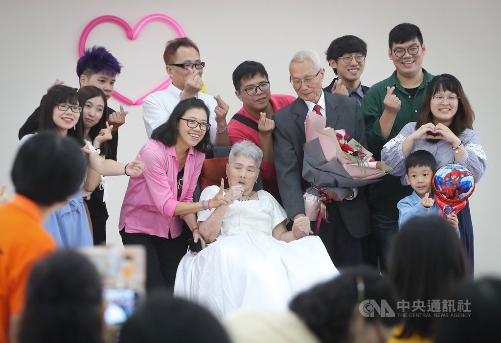 弘道老人福利基金會為83歲的阿公詹瑞東(拿花者)與太太韓水金(前中)圓夢,22日在內湖五分區民活動中心舉辦婚禮,兩人接受親友祝福。中央社記者裴禛攝 108年9月22日
