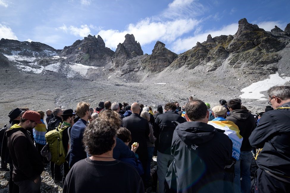 約100名瑞士居民22日穿黑衣爬上海拔近3000公尺的皮措爾山,緬懷逝去的冰川。(法新社提供)