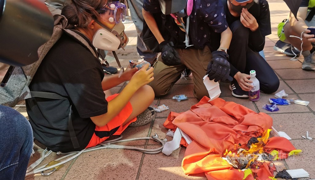 香港反送中人士21日下午舉行遊行,其中有人在屯門大會堂旁拉下中國國旗並燒燬。中央社記者張謙香港攝 108年9月21日