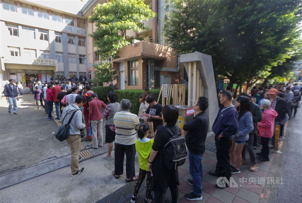 2018年九合一選舉發生投、開票亂象,中央選舉委員會主委李進勇23日表示,2020大選將增設1346個投票所。圖為2018年投票日民眾在投票所前大排長龍。(中央社檔案照片)