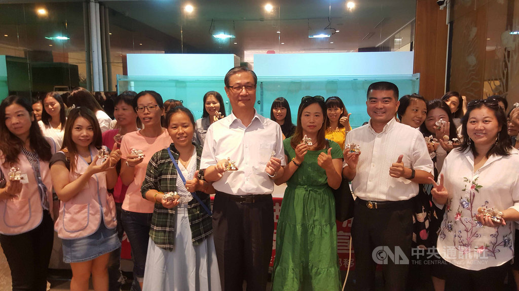 移民署行動服務列車24日開抵澎湖,副署長鐘景琨(中)等人在新住民家庭教育多元文化體驗活動,與新住民姐妹們利用珊瑚、貝殼等,結合在地文化一起製作手工藝品。中央社 108年9月24日