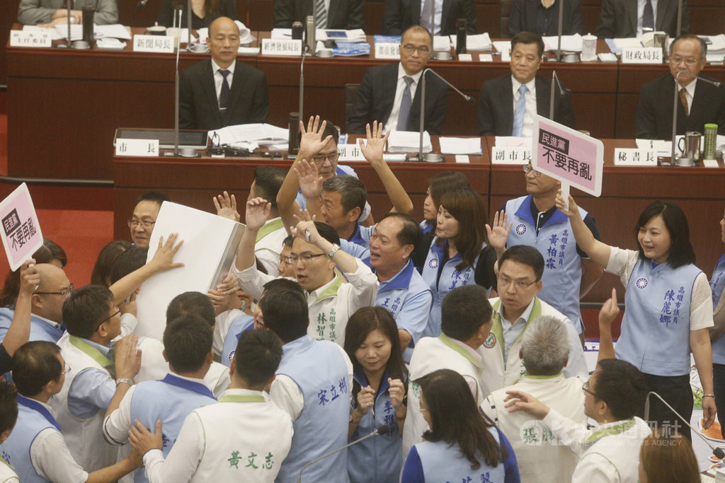 高雄市議會26日進行市政施政報告與質詢,民進黨議員鄭孟洳要求市長韓國瑜(後排右4)允諾總質詢不要請假,並送上「辭職書」促韓辭職再去選舉,但被國民黨議員包圍擋下,雙方爆發肢體衝突。中央社記者董俊志攝 108年9月26日