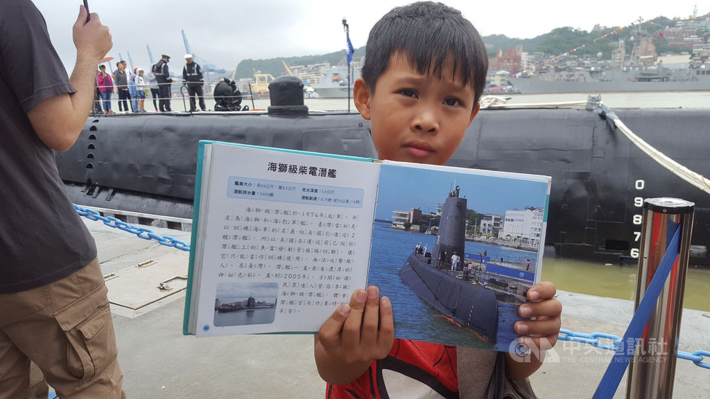 海軍司令部28日在基隆港舉辦營區開放活動,展示各型軍艦等,一名男童特地帶著百科全書前來排隊,等待進入海獅號潛艦參觀。中央社記者王朝鈺攝 108年9月28日