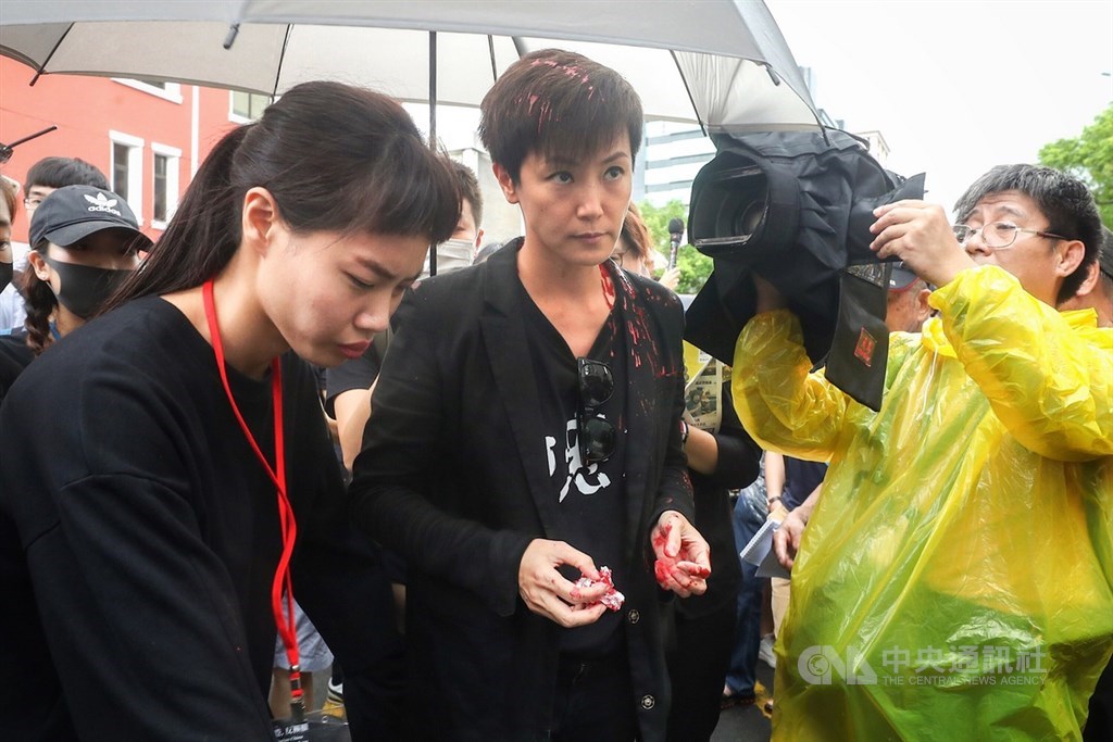 香港歌手何韻詩(前中)29日下午在台北參加「929台港大遊行:撐港反極權」活動,受訪時突遭蒙面男子潑紅漆。中央社記者裴禛攝 108年9月29日