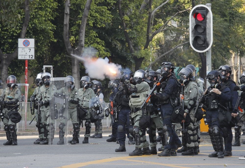 香港反送中持續延燒,其中港警在執法和言行上,始終備受爭議。圖為港警10月1日在香港沙田向反送中示威者發射催淚彈。(美聯社)