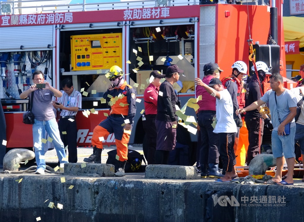 宜蘭縣南方澳跨港大橋1日斷裂坍塌,2日上午尋獲第4名菲律賓籍移工遺體,罹難移工同鄉朋友在岸邊灑冥紙,氣氛悲戚。中央社記者邱俊欽宜蘭攝 108年10月2日