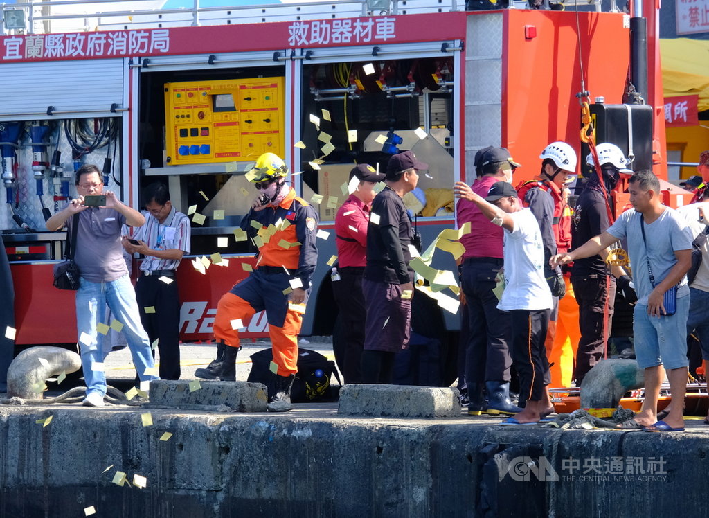 宜蘭縣南方澳跨港大橋1日斷裂坍塌,2日上午尋獲第4名菲律賓籍移工遺體,罹難移工同鄉朋友在岸邊灑冥紙,氣氛悲戚。中央社記者邱俊欽宜蘭攝 108年10月2日