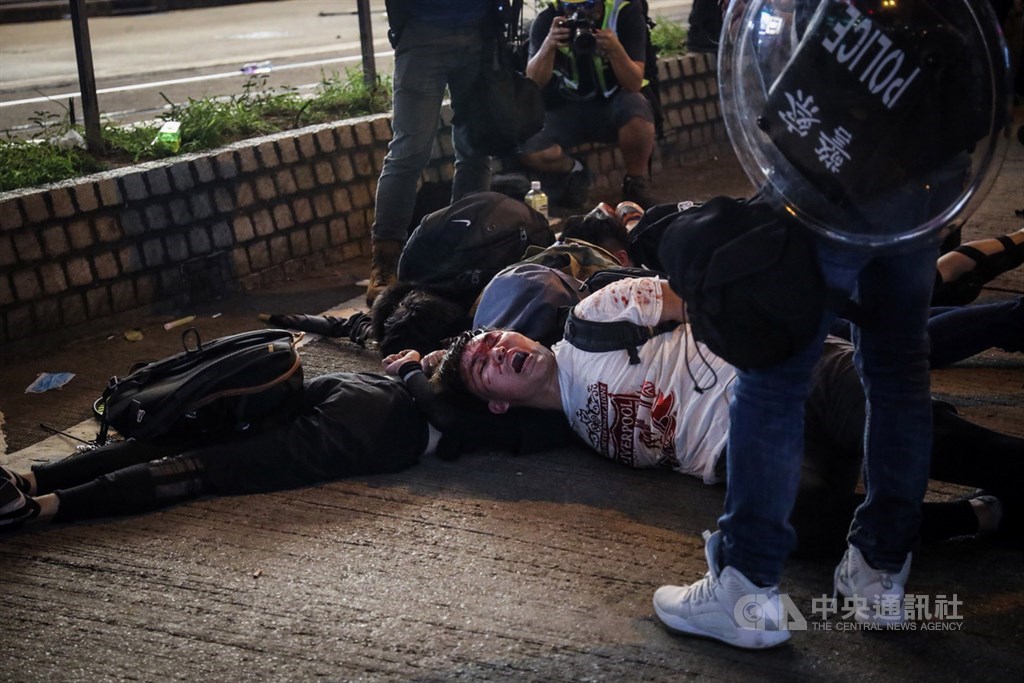香港「反送中」示威者8月11日與港警對峙,警方在銅鑼灣以突擊方式逮捕示威者,示威者被壓制在地。中央社記者吳家昇攝 108年8月11日