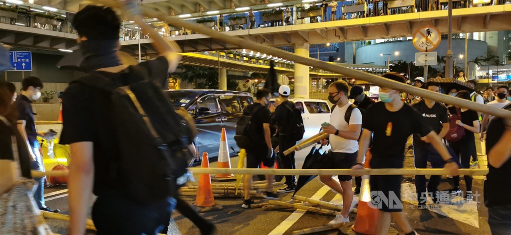 香港行政長官林鄭月娥4日宣布5日起正式實施「禁蒙面法」後,香港多地出現戴著口罩的示威者聚集抗議。圖為遊行人士堵住中環干諾道中的一條隧道。中央社記者張謙香港攝 108年10月4日