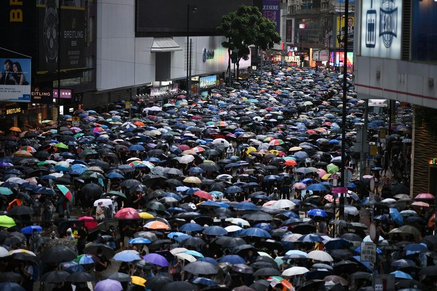 香港政府頒布「禁蒙面法」第2天,示威者6日下午在港島、九龍兩地,冒雨兵分多路上街抗爭。(法新社提供)