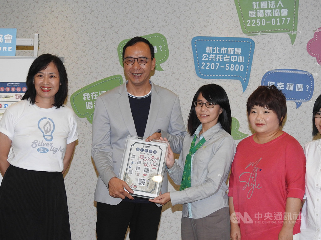前新北市長朱立倫(左2)7日出席「重陽獻好禮-青銀共創銀光生活」記者會,贈送長輩「銀光巡寶圖」,以QR code貼紙來防止長輩走失,保護長者安全。中央社記者王鴻國攝 108年10月7日