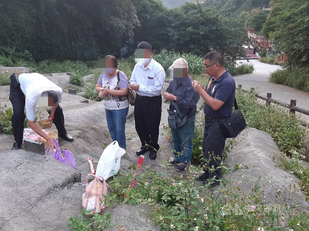 一具埋葬14年無名女屍,經基隆市警察局第一分局第三組組長許耀彬(右)比對上千筆資料後終於確認身分,家屬8日前往墓區不禁淚流滿面,再三向許耀彬道謝。(翻攝照片)中央社記者王朝鈺傳真 108年10月9日