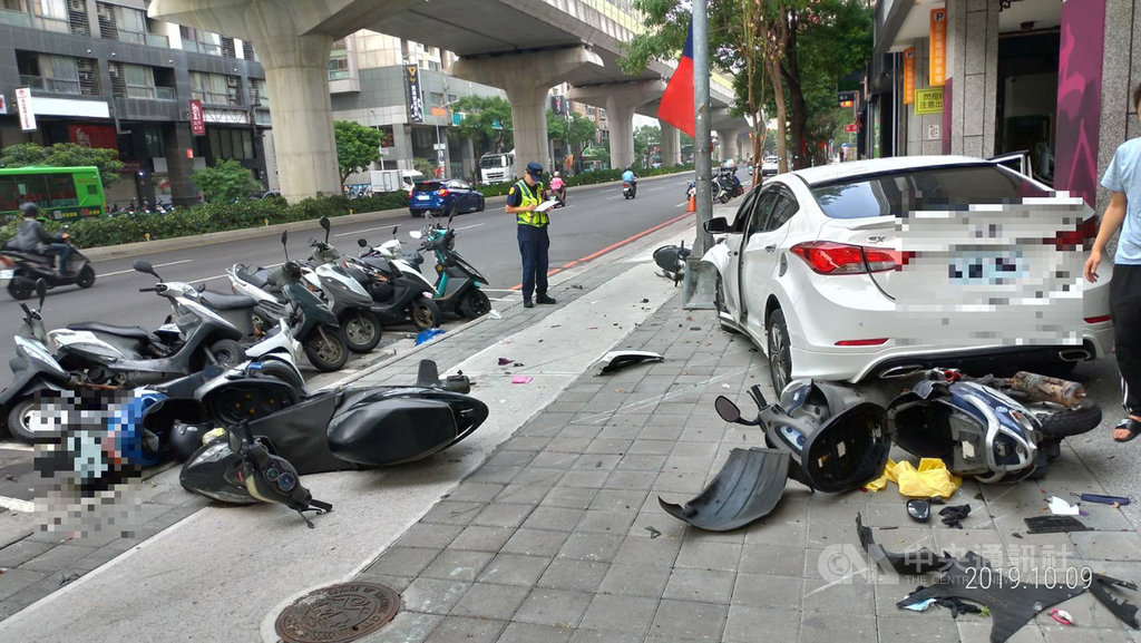 24歲邱姓男子駕駛白色自小客車,9日行經台中市北屯區文心路、山西路口時,車輛失控衝上人行道,波及路旁13輛機車,零件散落一地。(民眾提供)中央社記者趙麗妍傳真 108年10月9日