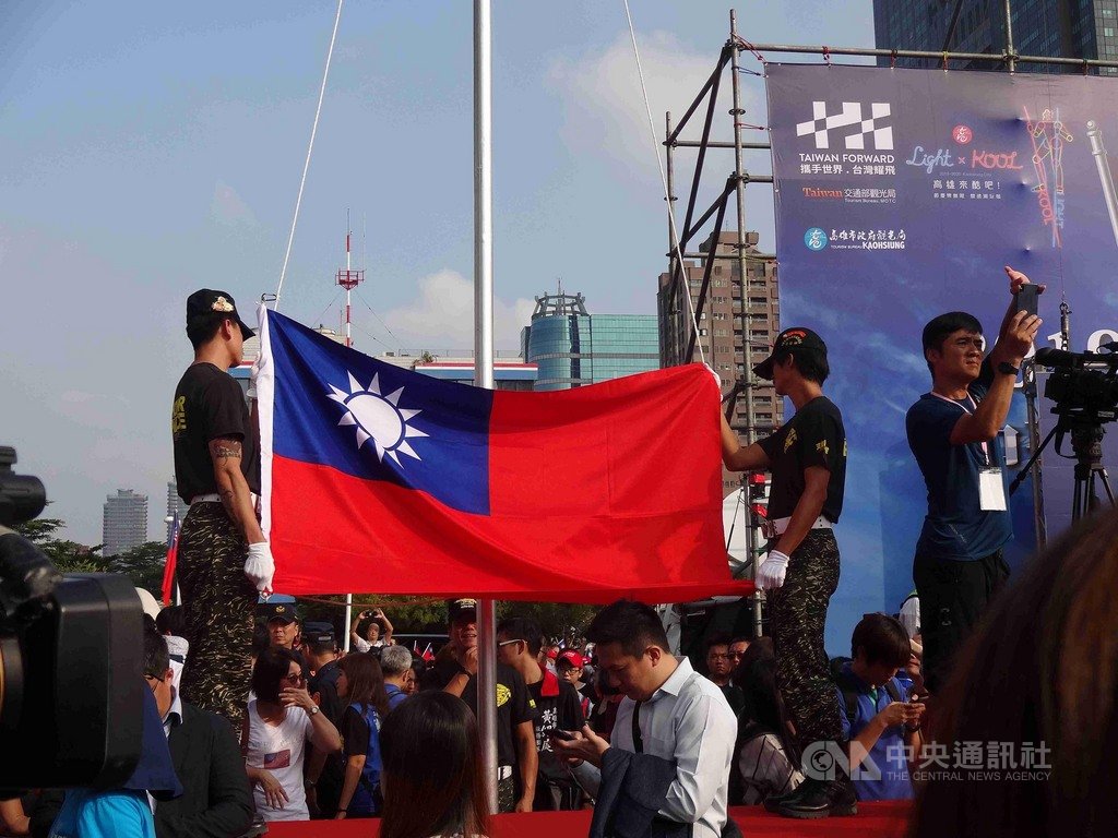 高雄市國慶升旗典禮10日舉行,由市長韓國瑜帶領參加民眾唱國歌,現場與附近道路都湧入揮舞國旗和穿國旗裝的人潮。中央社記者陳朝福攝 108年10月10日