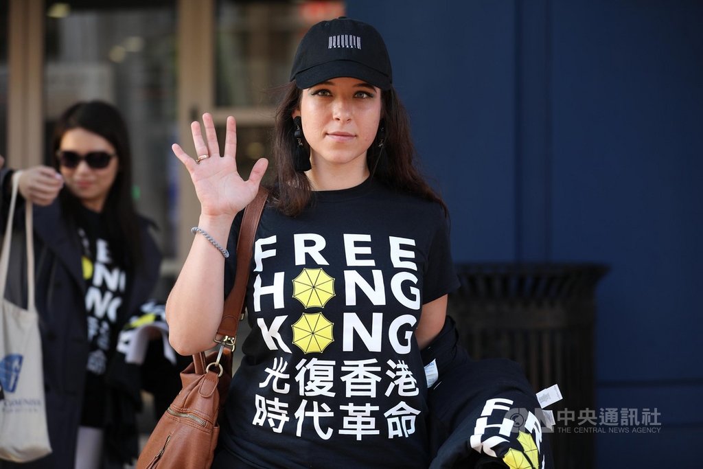 美國國會授權成立的「共產主義受害者紀念基金會」人員身穿挺香港T恤,在華府市區體育館外比出手勢,象徵香港反送中運動的「五大訴求,缺一不可」。中央社記者徐薇婷華盛頓攝 108年10月10日