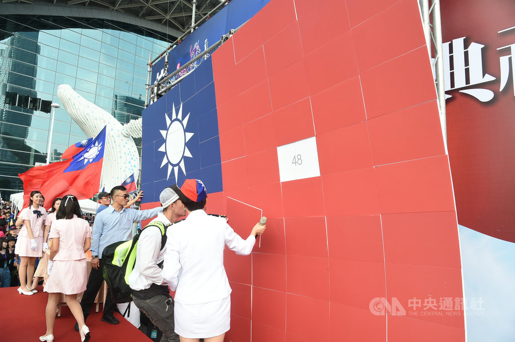 高雄市國慶升旗典禮10日在高雄展覽館旁舉行,高雄市長韓國瑜致詞時,舞台後方拼製而成的巨幅國旗背板突然傾倒掉落,工作人員趕緊扶起。中央社記者董俊志攝 108年10月10日