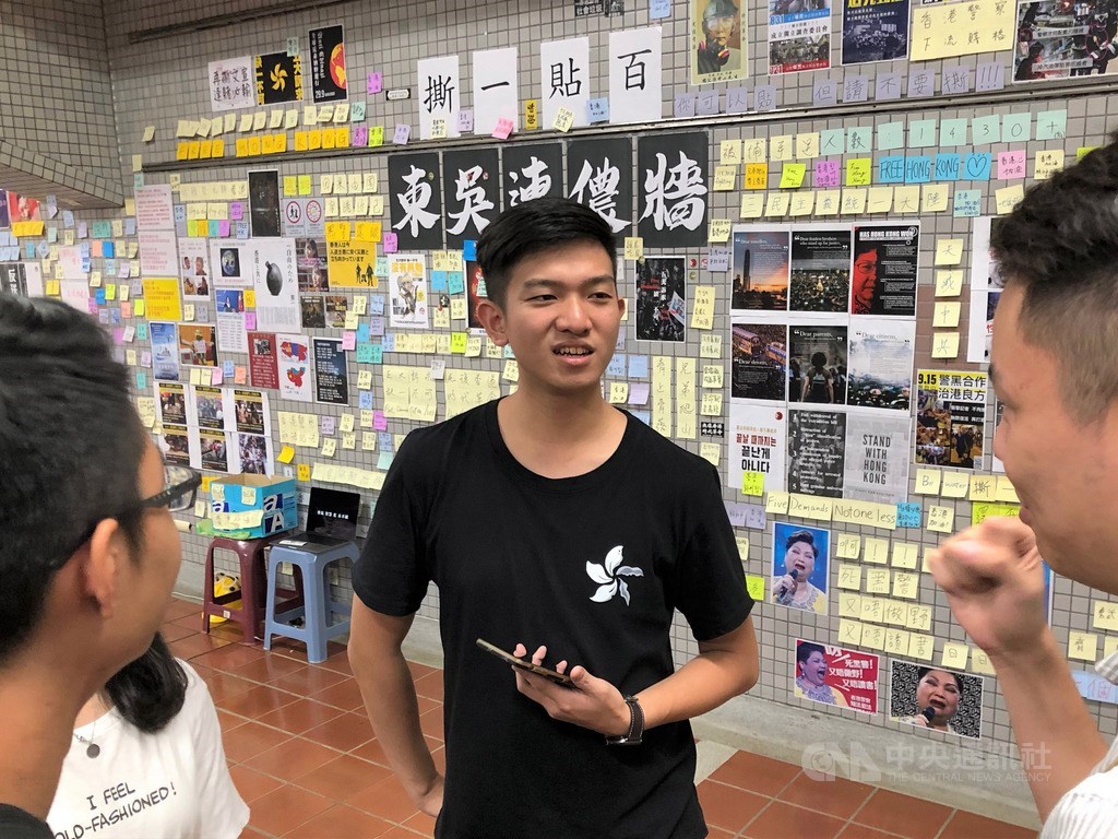 東吳大學香港籍學生Jackson(中)發起聲援香港「反送中」的連儂牆,日前遭到破壞,目前連儂牆已擴張至原來的2倍大,Jackson表示,如果對「反送中」有什麼意見,都歡迎在連儂牆上表達,「用簡體字也不是問題」。(中央社檔案照片)