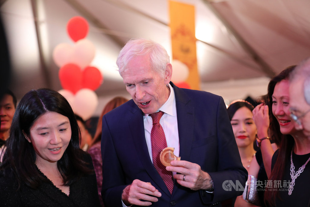 美國在台協會主席莫健出席駐美代表處國慶活動,莫健在典禮場邊品嚐印有TRA@40、象徵台灣關係法40週年的台灣口味車輪餅。中央社記者徐薇婷華盛頓攝 108年10月11日