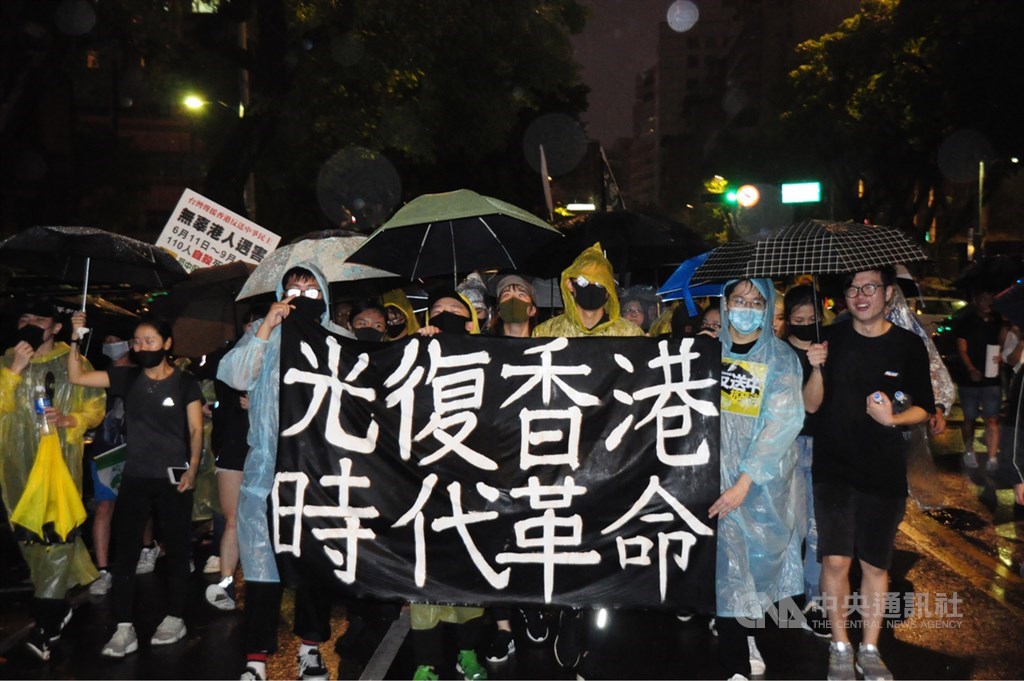 多個公民團體29日舉辦「929台港大遊行-撐港反極權」活動,一群在台港人手持「光復香港,時代革命」標語,高喊口號行進。(中央社檔案照片)