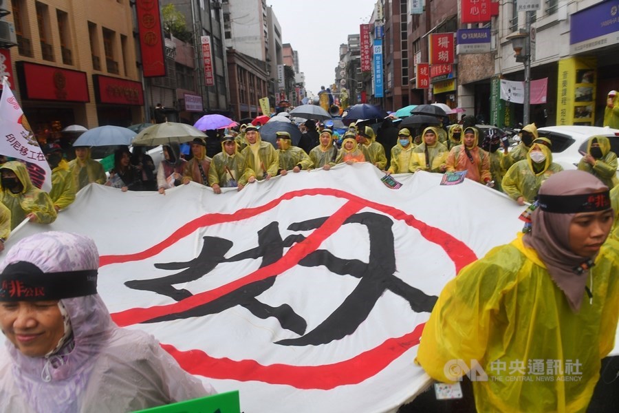 移工來台已30年,但不論產業或是社福移工,勞動條件都有差強人意之處。圖為2018年台灣移工聯盟發起「看見非公民大遊行」,移工們在雨中拉布條、呼口號表達訴求。(中央社檔案照片)