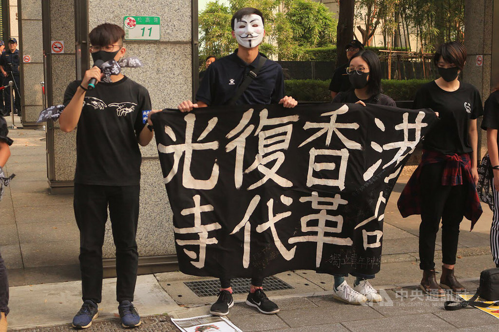 來自東吳、政大等多校的在台港生及聲援者,12日穿著黑衣到位於台北市信義區的香港經濟貿易文化辦事處外,抗議港警暴行及港府推動「禁蒙面法」。(香港邊城青年提供)中央社記者陳至中傳真 108年10月12日