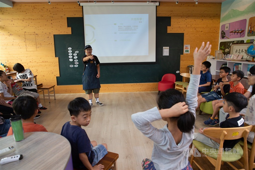 甜點師李奇芳(立者)選擇走入偏鄉教孩子們做甜點,歷經不斷的修正與反思,如今她的烘焙課程,都會先和小朋友聊聊蛋糕演化史,然後挑出幾項讓小朋友動手作,加深他們的印象。中央社記者謝佳璋攝 108年10月12日