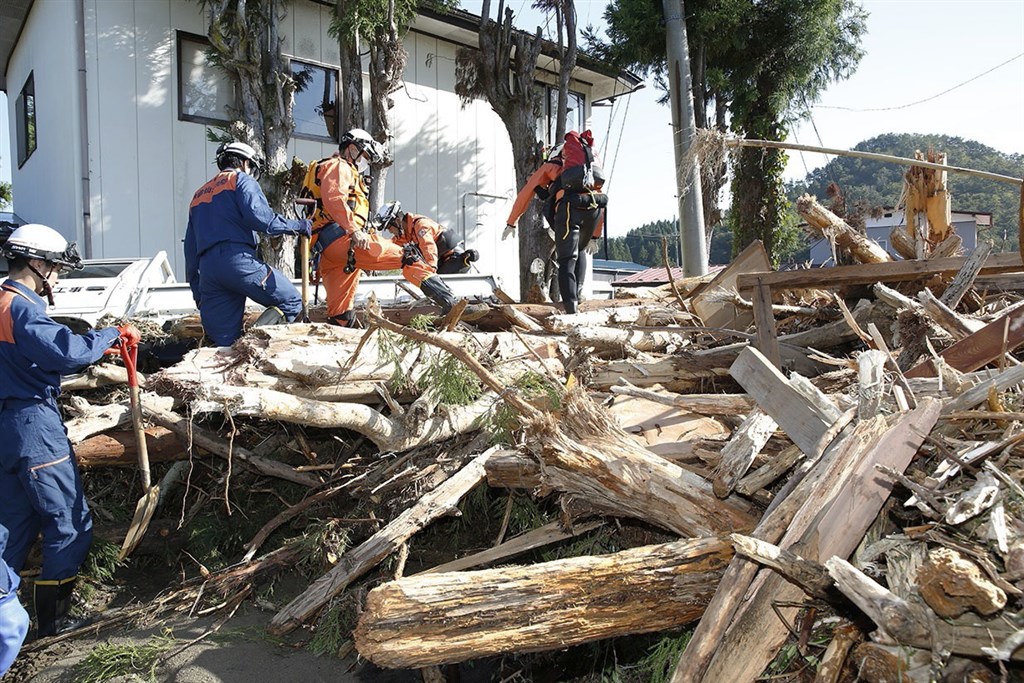 日本受到颱風哈吉貝肆虐,截至日本時間晚間6時30分,至少已造成26人死亡、18人失蹤,及175人受傷。圖為13日下午消防員在宮城縣丸森町救災。(共同社提供)