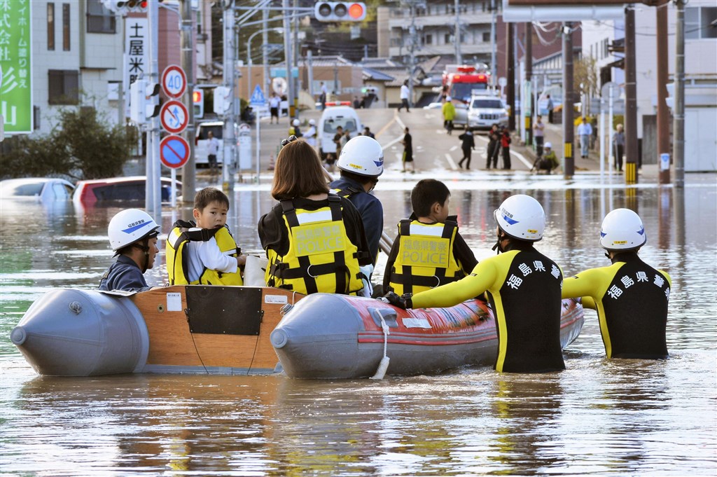 颱風哈吉貝侵襲日本部分地區,救難人員協助救出因淹水受困的民眾。(共同社提供)