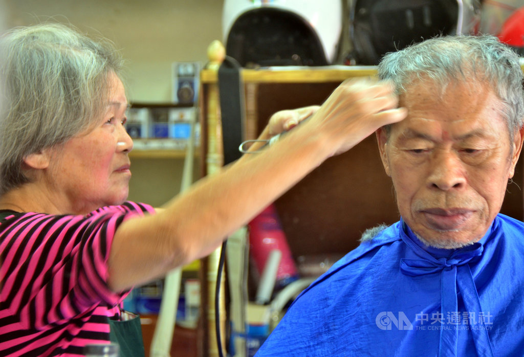 縱使行動不便、需往返100公里的車程,90歲吳姓老翁(右)每個月仍堅持要讓79歲的韓梅子(左)剪頭髮。韓梅子說,這個頭,她剪超過600次了。中央社記者盧太城台東攝 108年10月15日