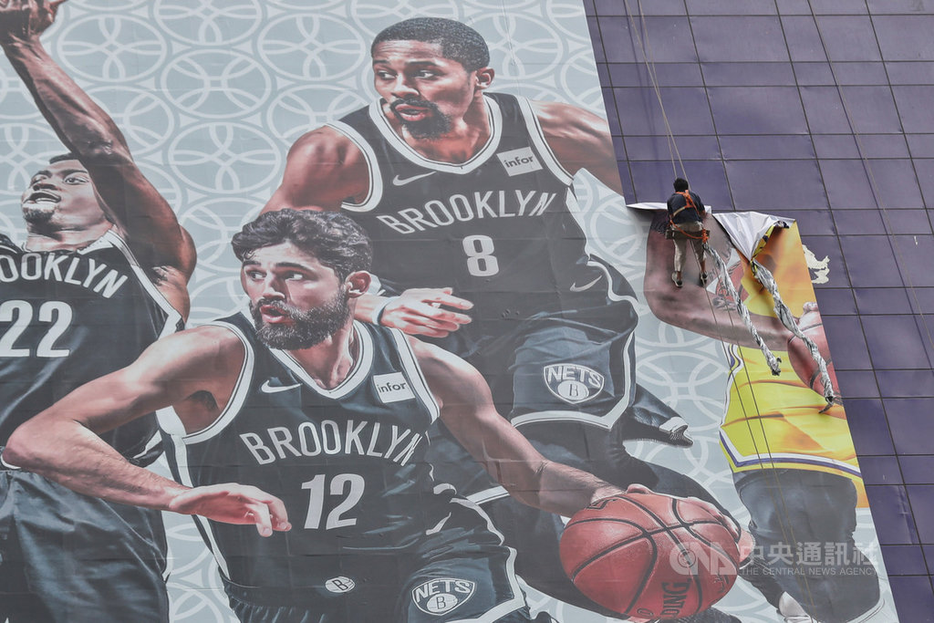 NBA風波後,騰訊悄悄恢復轉播,中國媒體記者表示,應是獲有關單位某程度的認可;但同為轉播單位的央視是三大官媒之一,動見觀瞻,是否跟進復播,仍有待條件成熟。圖為9日「2019NBA中國賽」記者會取消時,工作人員將會場外的NBA巨型海報撤下。(中新社提供)中央社 108年10月15日