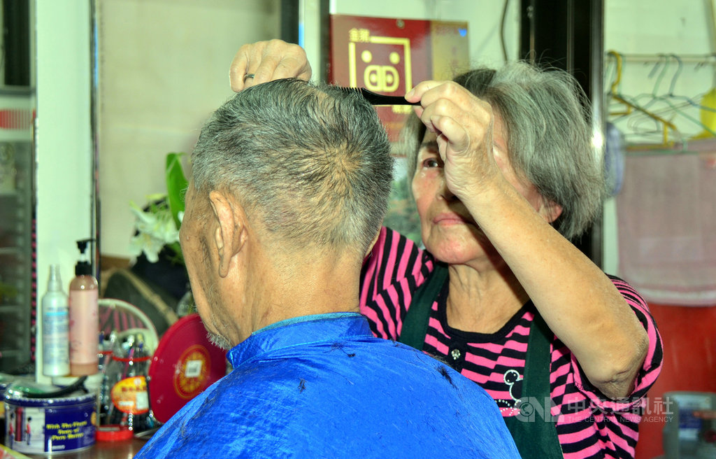 90歲的吳姓老翁(左)每個月堅持要讓79歲的理髮師傅韓梅子(右)剪頭髮,韓梅子說,從民國55年到現在,吳先生每個月都會到這裡理髮,已有53年,「這個頭我剪超過600次了」。中央社記者盧太城台東攝 108年10月15日