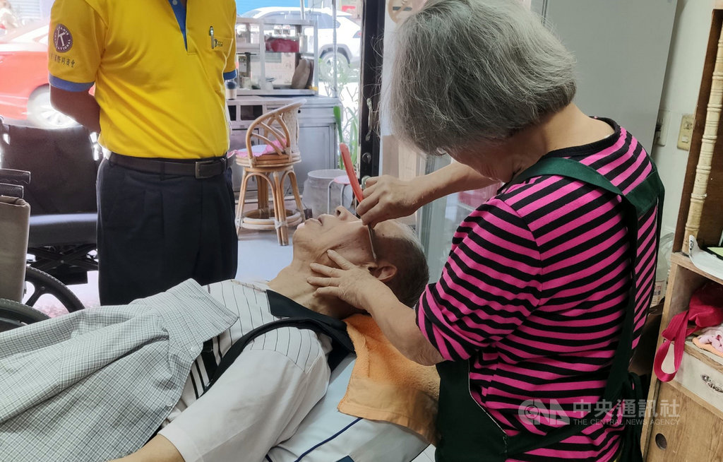 縱使行動不便,90歲的吳姓老翁(左)每個月堅持要讓79歲的理髮師傅韓梅子(右)剪頭髮,不僅信賴,還有50餘年的交情。中央社記者盧太城台東攝 108年10月15日