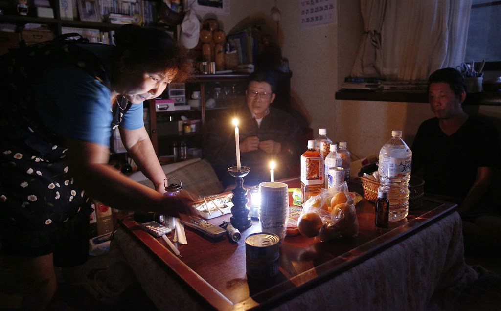 截至15日清晨,東北電力公司供電區域,包括宮城縣、岩手縣、福島縣等部分地區,仍有約1600戶停電。圖為13日傍晚宮城縣停電,民眾自備蠟燭因應。(共同社提供)