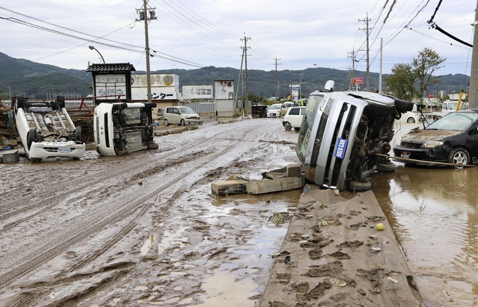 強颱哈吉貝襲擊日本至15日凌晨已造成58人喪生,再度下起的大雨可能會阻礙全日數萬名救難人員搜救生還者的工作。長野縣災區滿地泥濘的公路上有許多翻覆車輛。(共同社提供)