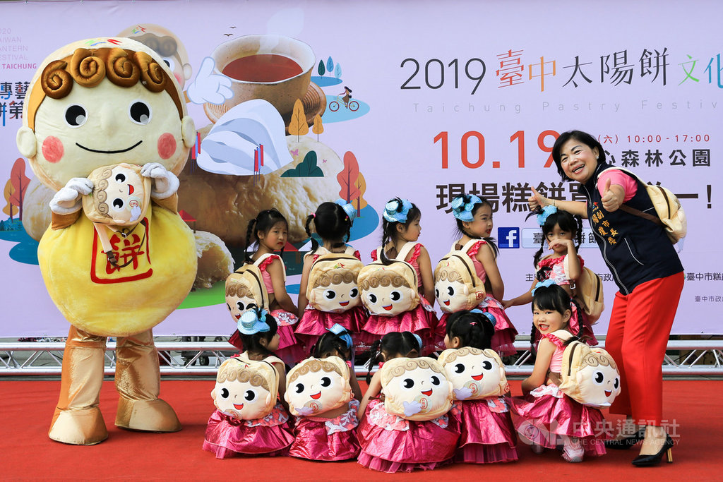 2019太陽餅文化節將於19日登場,台中市政府16日舉辦宣傳活動,台中市副市長楊瓊瓔(右)與小朋友公布今年消費滿額限量禮「餅寶貝」背包。中央社記者郝雪卿攝 108年10月16日