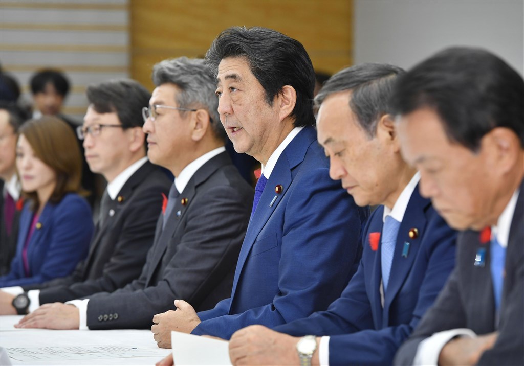 颱風哈吉貝重創日本部分地區,救難人員還在與時間競賽搜尋生還者,希望恐怕愈來愈渺茫,但首相安倍晉三(右3)16日表示將持續搜救。(共同社提供)