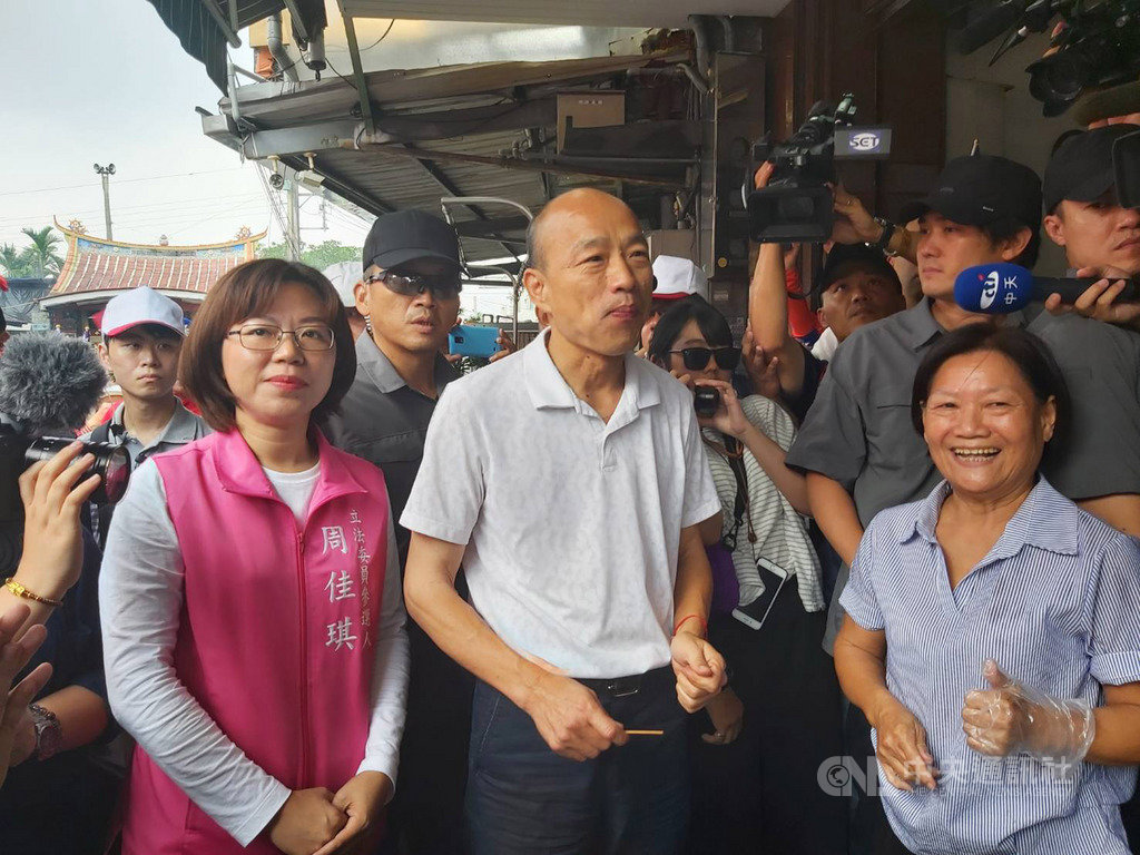 國民黨總統參選人韓國瑜(前中)17日到屏東縣萬巒豬腳街拜訪,祝賀下週將登場的萬巒豬腳節順利,還有熱情店家請韓國瑜吃豬腳。中央社記者郭芷瑄攝 108年10月17日