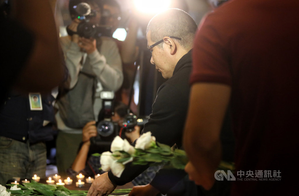 台鐵普悠瑪列車在宜蘭新馬站翻覆事故即將屆滿一年,台灣鐵路產業工會17日晚間舉行普悠瑪對年追思晚會,司機員尤振仲(中黑衣者)也到場獻花向罹難者致意。中央社記者王騰毅攝 108年10月17日