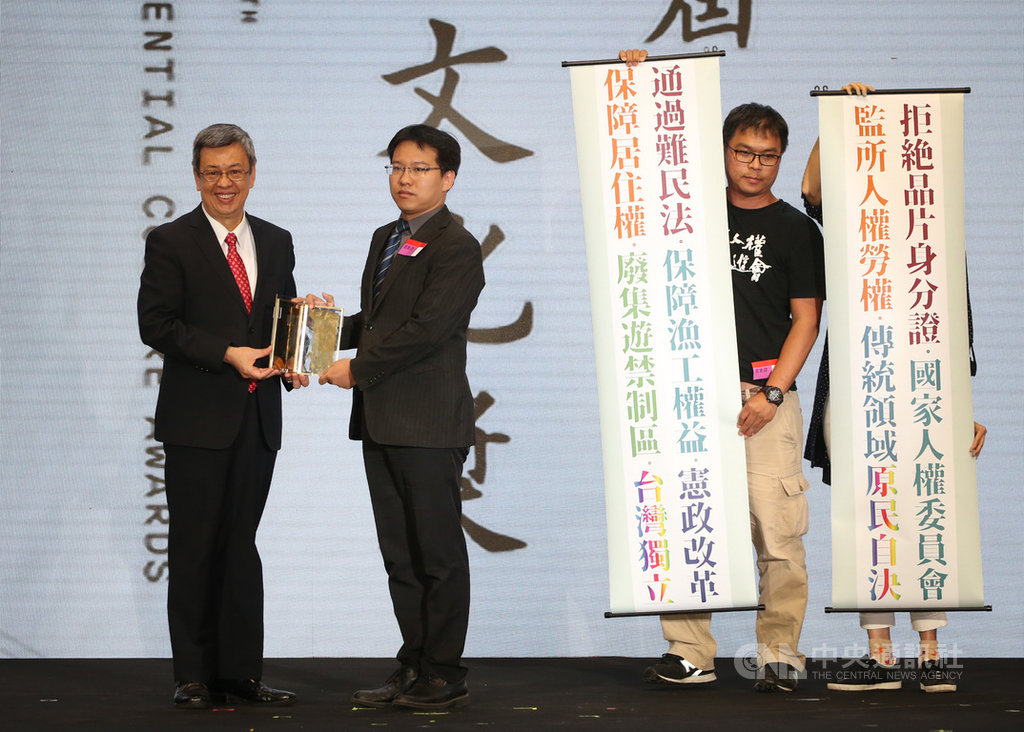 2019第10屆總統文化獎18日晚間在松山文創園區舉行頒獎典禮,副總統陳建仁(左)頒發獎座給今年社會改革獎得主「台灣人權促進會」,一旁並有促進會成員秀出標語,傳達訴求理念。中央社記者鄭傑文攝 108年10月18日