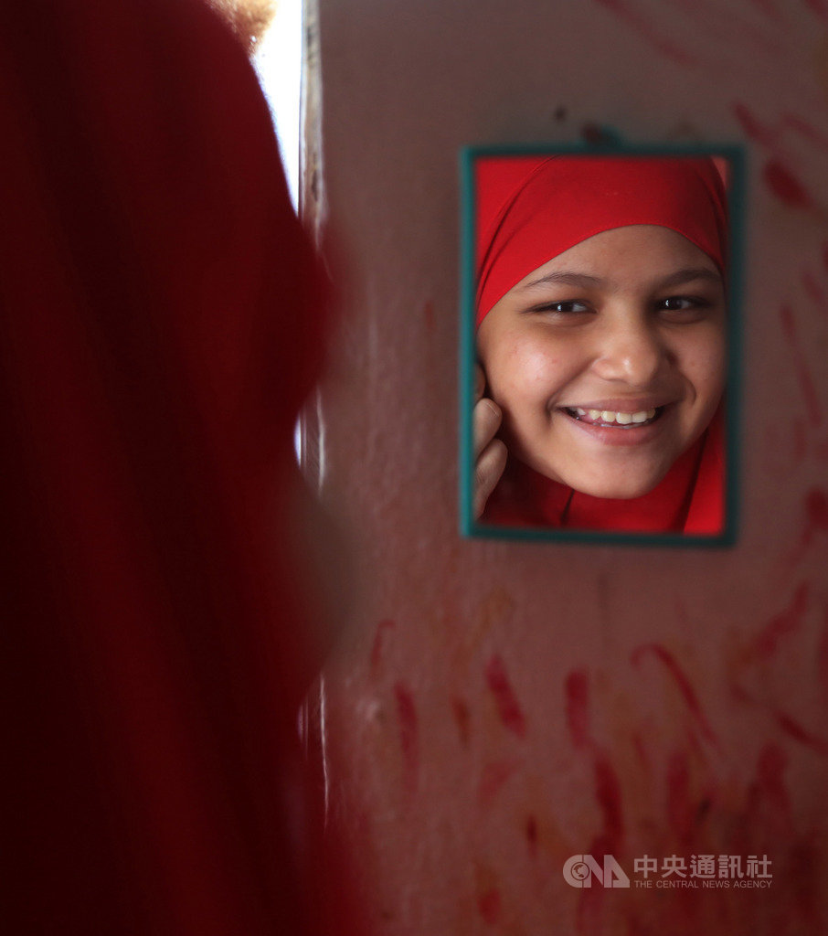 吉隆坡近郊陳舊公寓裡,13歲洛興雅少女畢比愛莎沒有少女夢幻般梳妝台,僅使用掛在斑駁牆壁上小鏡子打理儀容,現實生活環境雖無奈,她仍樂觀面對。中央社記者黃自強吉隆坡攝 108年10月18日