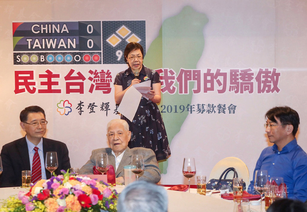 李登輝基金會19日晚間在台北舉辦2019募款餐會,前總統李登輝(前左2)出席與會,由女兒李安妮(後)代表上台致詞。中央社記者裴禛攝 108年10月19日