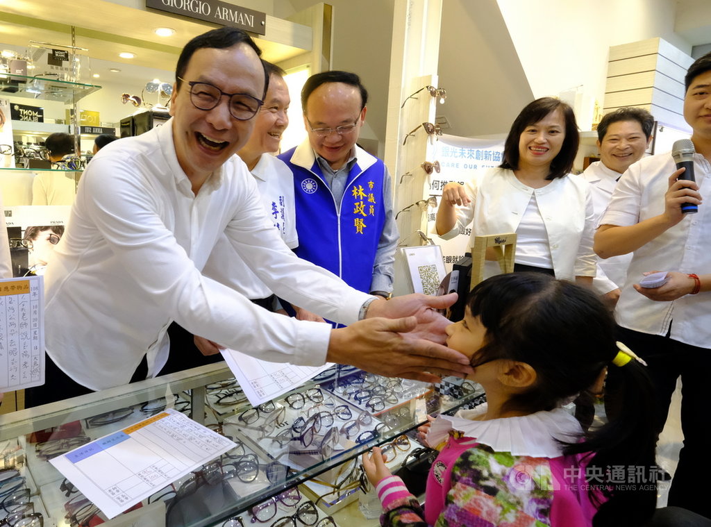 前新北市長朱立倫(左)在新北市推動的「免費敬老眼鏡」計畫20日移師桃園,他感謝在地公益眼鏡行及熱心志工一起大力支持,成就這項非常具有意義的活動,並與陪同阿嬤配眼鏡的小朋友溫馨互動。中央社記者邱俊欽桃園攝 108年10月20日