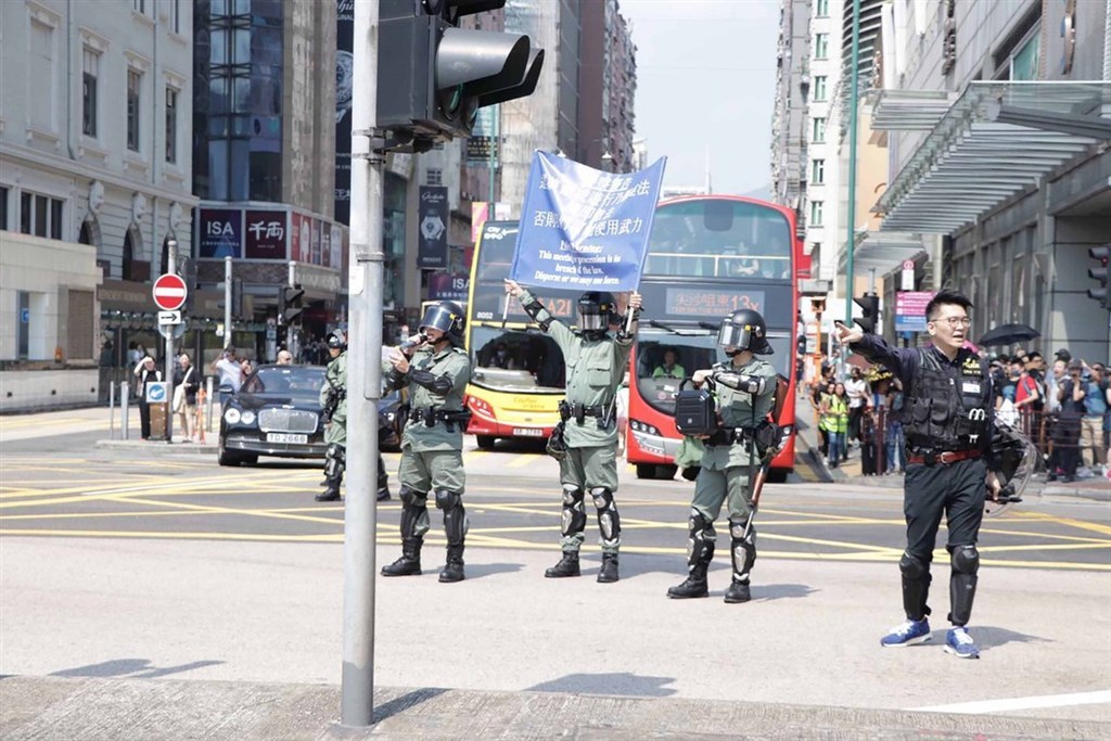 香港民間人權陣線原定20日下午在尖沙咀發起遊行,但日前遭警方否決。中午12時30分左右,仍有大批市民陸續到集合地點文化中心附近,準備自行響應遊行。圖為遊行出發前,警方在現場舉起藍旗,警告這是非法集會。中央社記者張謙香港攝 108年10月20日