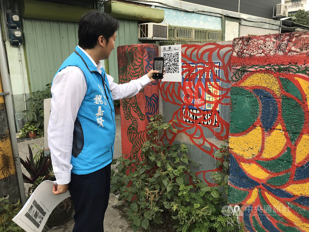 花蓮溝仔尾街區一群店家,趁著觀光淡季集結藝術家,辦起街區藝術季,花蓮市長魏嘉賢(圖)前往參觀並透過手機掃描QR code,聆聽「淡季-溝仔尾街區藝術季」的音樂作品。中央社記者張祈攝 108年10月22日